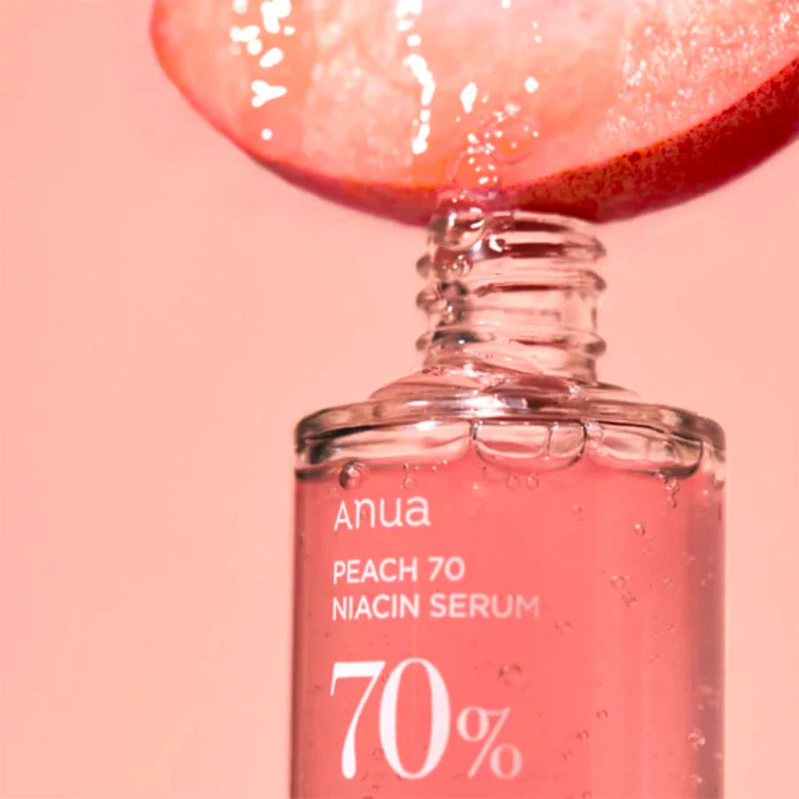 Anua 70 percent niacinamide serum in clear bottle with peach slice and pink liquid