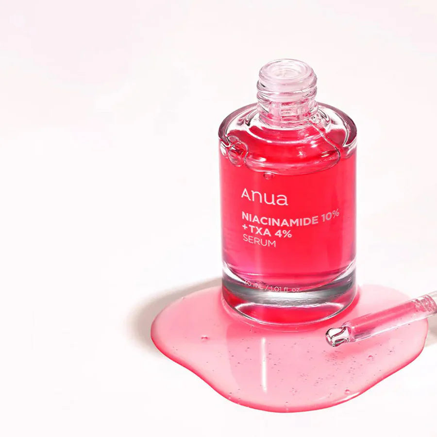 Anua brightening serum with TXA and niacinamide in a clear bottle with a pink serum drop