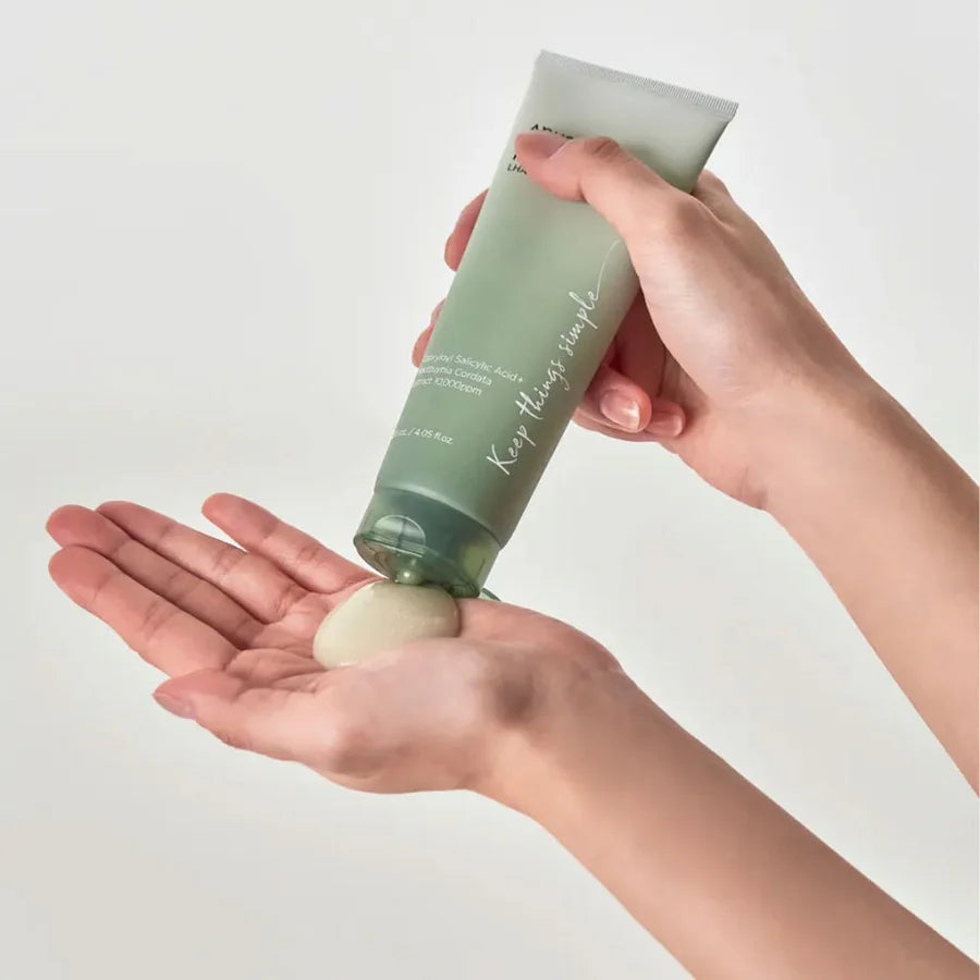 Anua heartleaf peeling gel being dispensed from green tube onto palm for gentle skin exfoliation