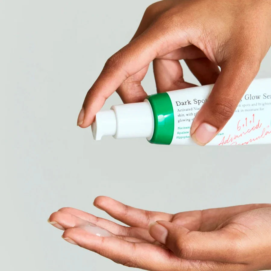 AXIS-Y dark spot correcting serum being dispensed from white and green bottle onto hand