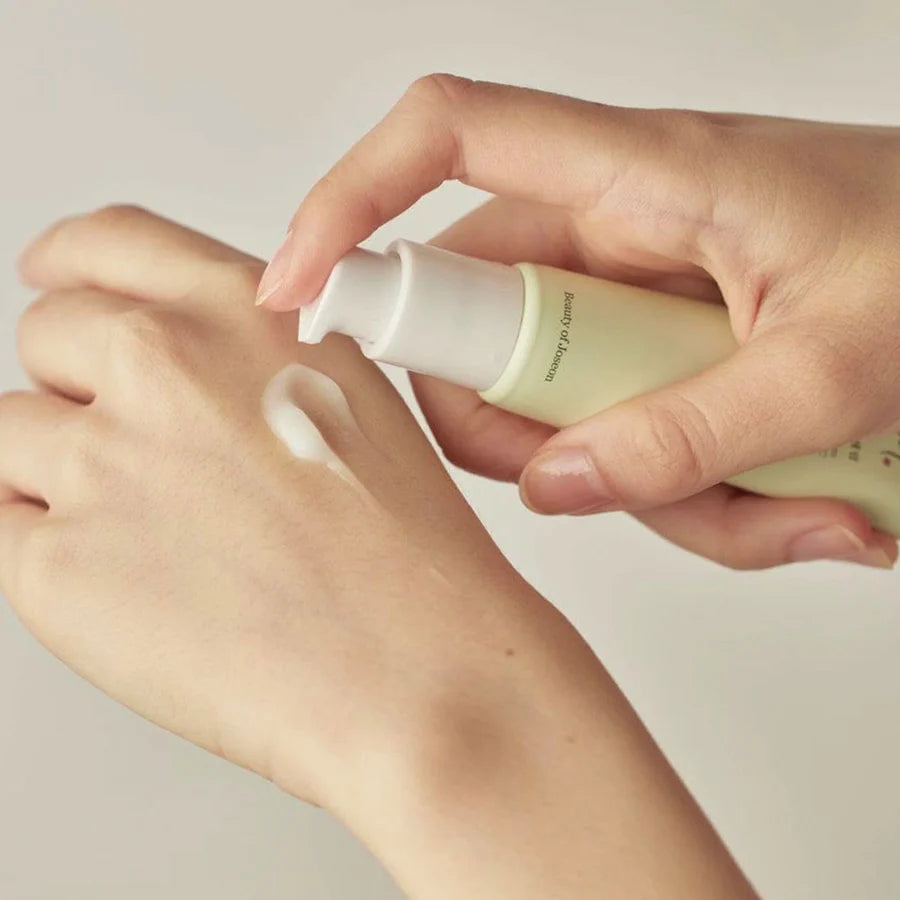 Beauty Of Joseon centella vitamin c serum being dispensed onto hand in light green bottle