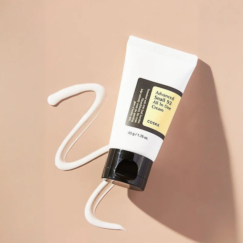 Cosrx advanced snail 92 all in one cream tube with cream swirled on beige surface