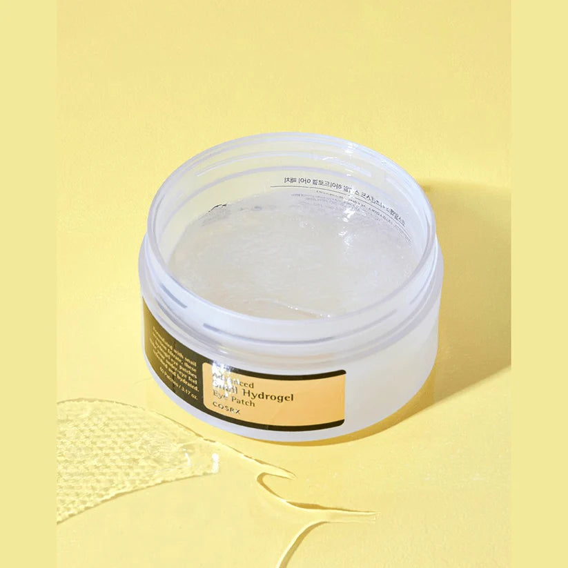 Cosrx snail hydrogel eye patch in open jar showing translucent patches on yellow background